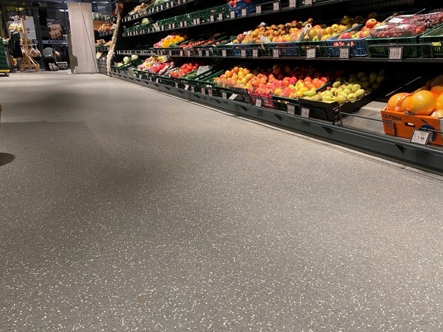 Obst- und Gemüseabteilung eines Supermarkts mit gesprenkeltem Boden